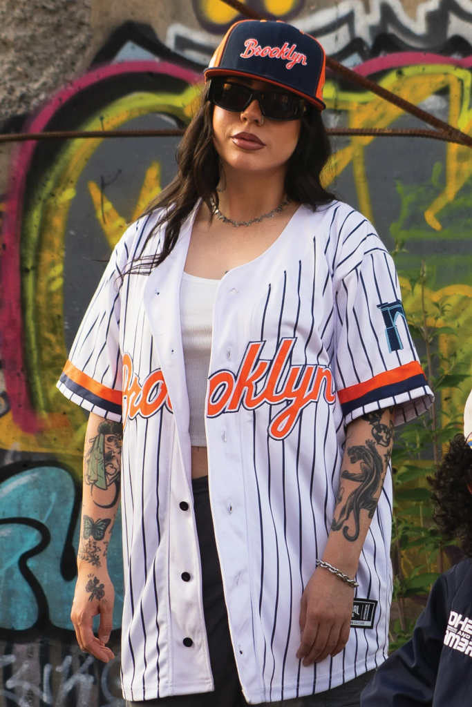 The Mosh Network - Model displaying The Coheed And Cambria Brooklyn Cyclones jersey and hat.