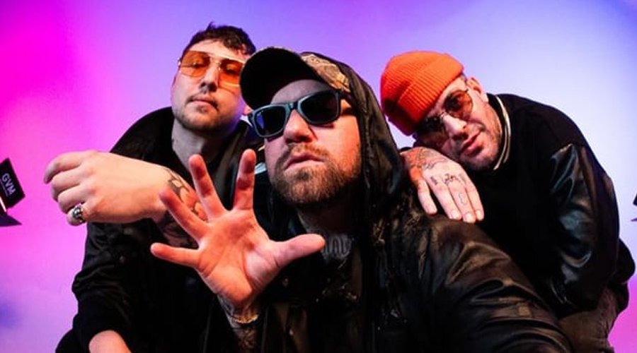 Attila Debut New Single “ATL”, Detail ‘CONCRETE THRONE’ Album The Mosh Network - Attila band promo of the three members huddled up with studio lighting arounc them. 2025.