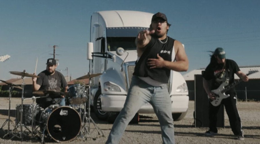 BIG ASS TRUCK I.E. Sign With Nuclear Blast, Debut “BACK-WHEEL STOMP” Video The Mosh Network - Big Ass Truck performing in front of a semi truck in the "Back Wheel Stomp" video 2025